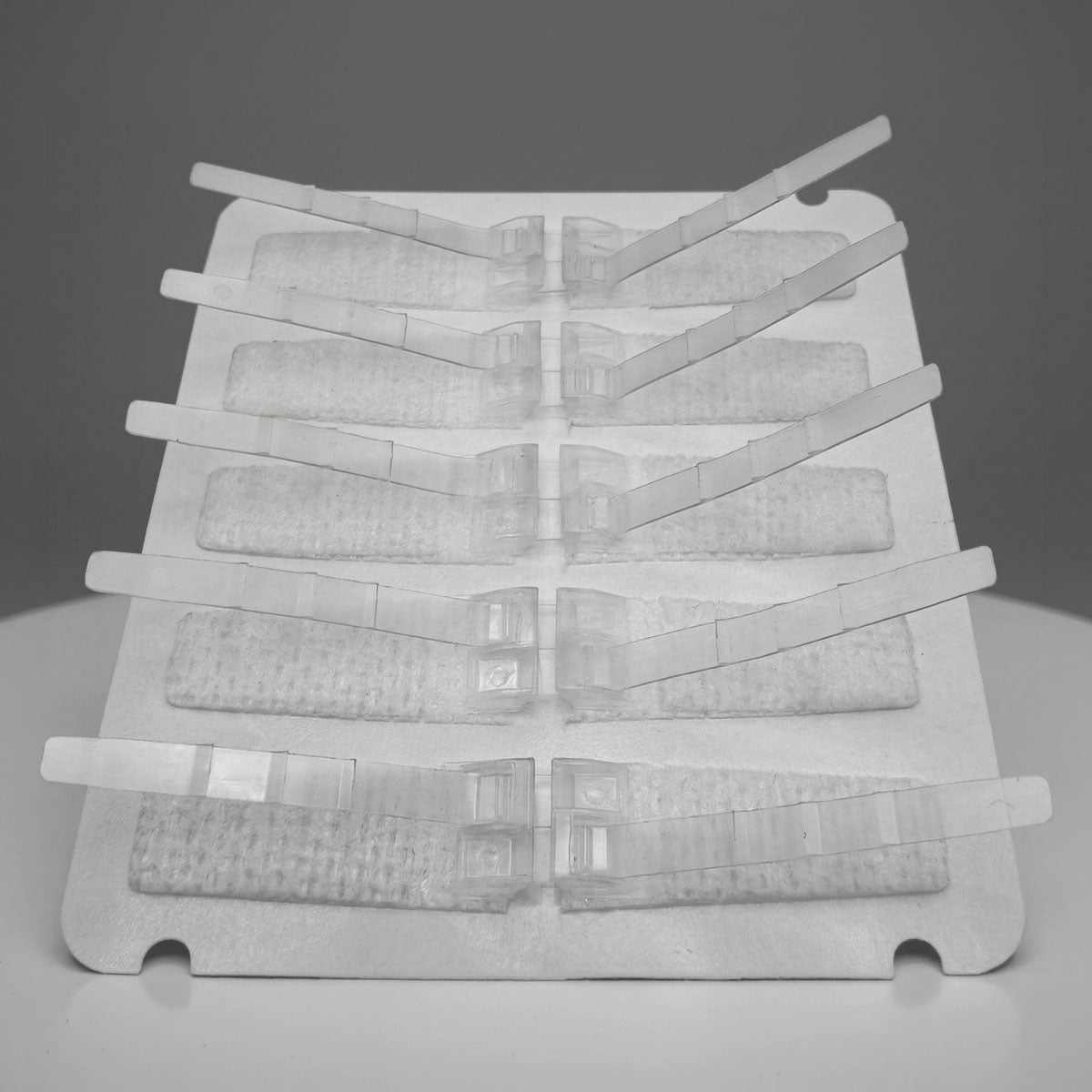DermaClip Regular 5-clip device — angled product view showing adhesive pads and closure mechanism - 62001